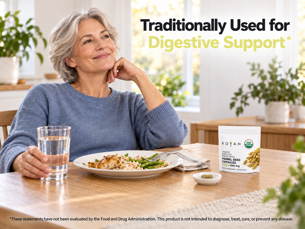 Woman smiling at a dining table with a meal, a glass of water and a KOYAH Organic Sprouted Fennel Seed Capsules pouch: traditionally used for digestive support
