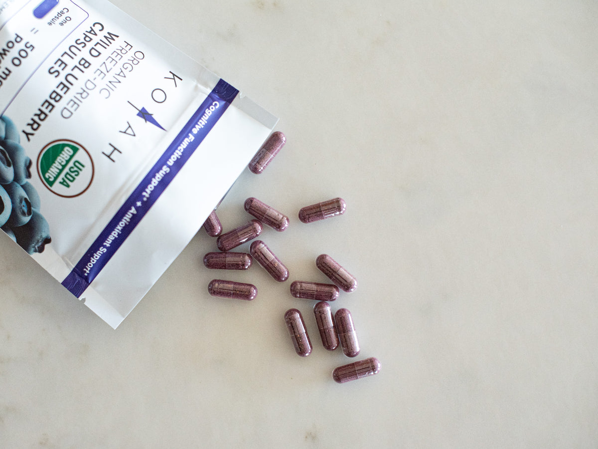 KOYAH Organic Wild Blueberry Capsules lifestyle photo, capsules spilling from pouch
