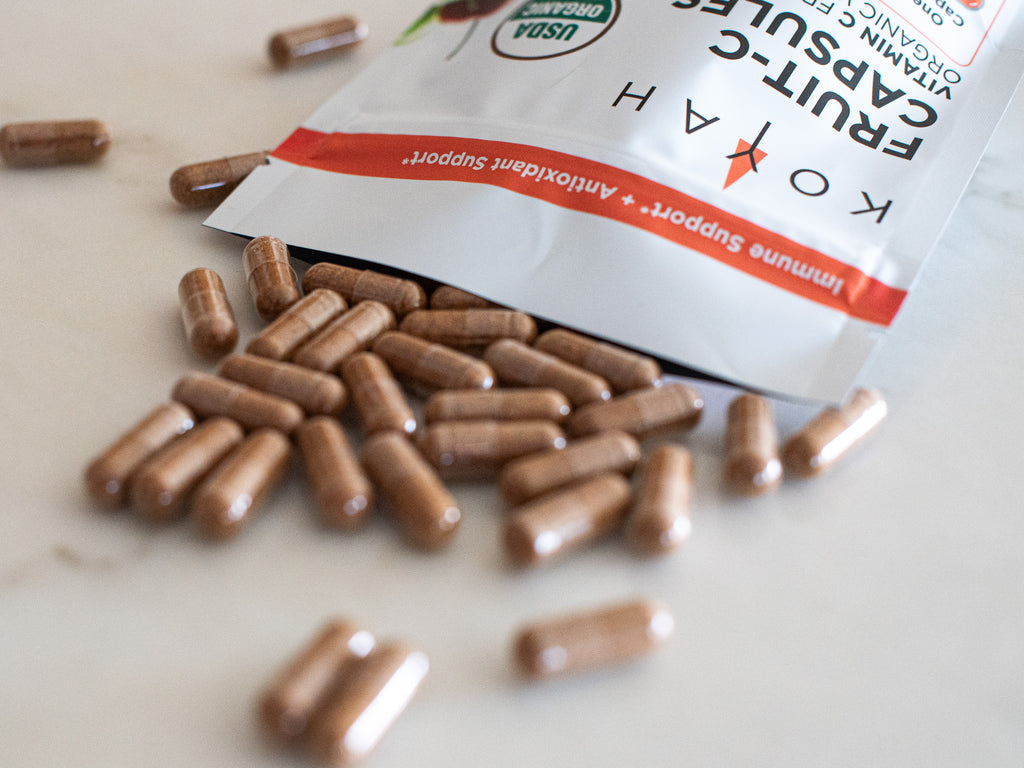 KOYAH Fruit-C organic vitamin C capsules spilling from resealable pouch