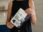 Person holding KOYAH Organic Acai Powder pouch — freeze-dried whole-berry acai, USDA organic certified